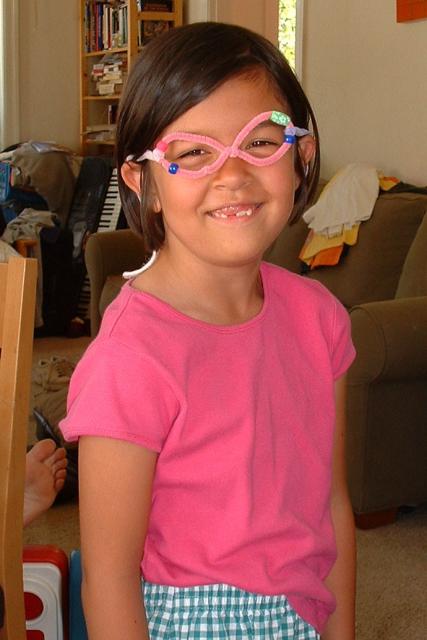 Maya (7 yrs) with homemade glasses and missing front teeth
(July 2003)