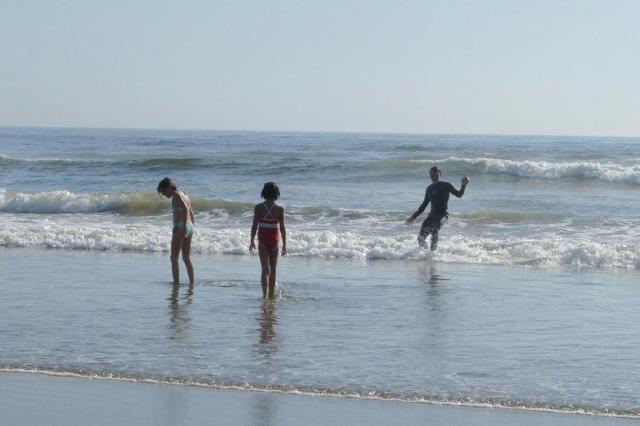 Carla and Maya 2006-16 - John surfing and Carla and Maya looking for whole sand dollars in the surf near Morro Rock.